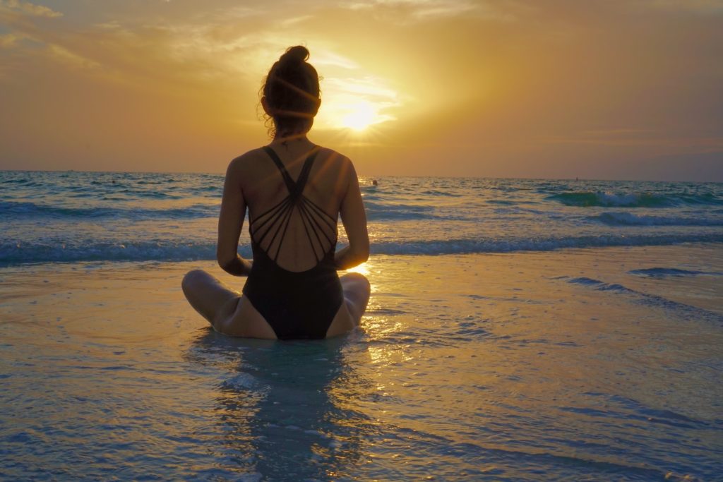 девушка медитирующая  на берегу 
