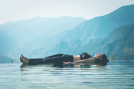 девушка выполняющая пузу йоги Нидра на воде